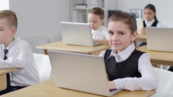 Caucasian Schoolgirl with Laptop Smiling for Camera in Class alt