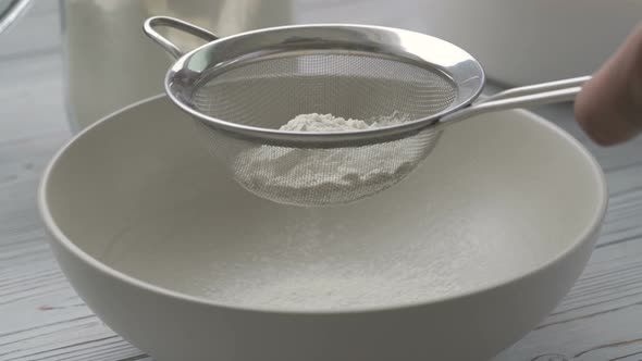Flour Sifting Through a Sieve for a Baking