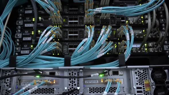 Fiber Optical Cables Close Up on Datacenter. Telecommunication Broadband. Blink Green Led Lights