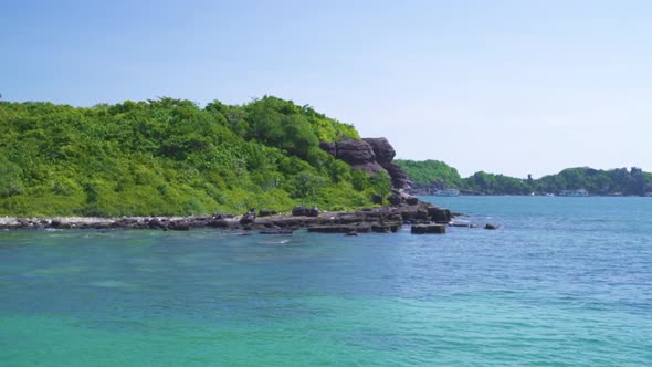 Scenic Island with Green Lush Rocky Cliffs and Blue Pristine Ocean Water.