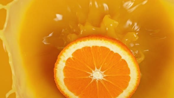 Super Slow Motion Shot of Orange Slice Splashing to Orange Juice at 1000Fps alt