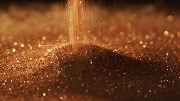 Gold glitter gems spilling on black background alt