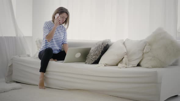 Young woman use smartphone and laptop to work alt