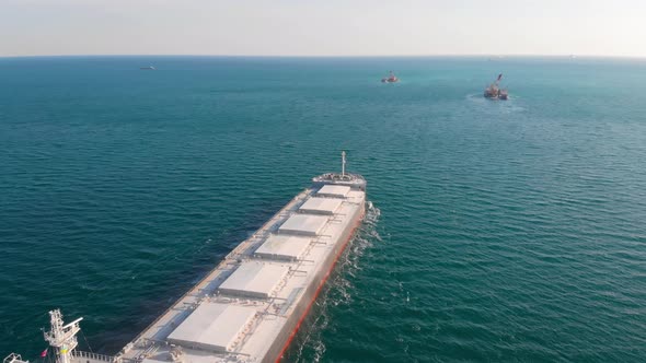 The Bulk Carrier Left the Port and Moves in the Right Direction at High Speed. alt