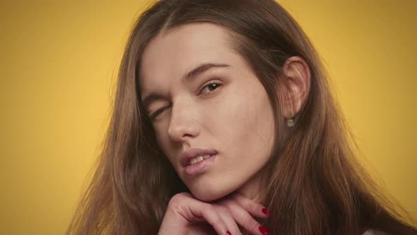 Young Adult Caucasian Woman Posing in Slow Motion on a Bright Yellow Background alt