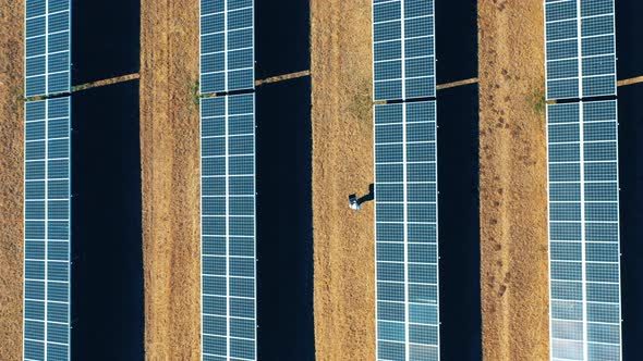 Top View of a Solar Power Station with a Man Walking Through It alt