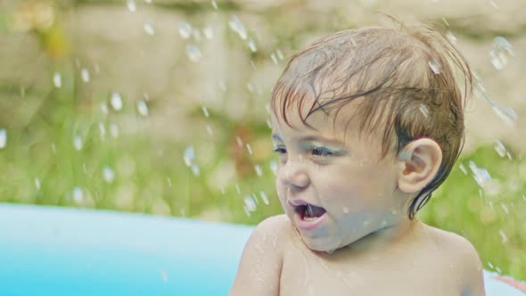Dad Splashes Water on His Son and Boy Laughs in Delight, Smiles. Adorable Little Baby Swimming in alt