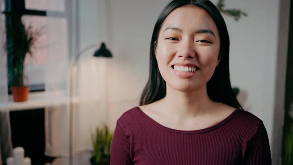 Close Up Portrait of Young Cute Asian Woman Smiling to Camera Posing at Home Interior Tracking Shot alt