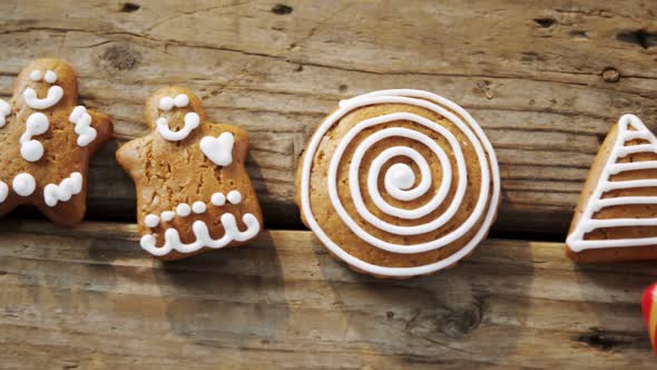 Various cookies and candy cane arranged on wooden table alt