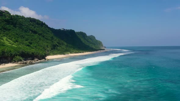 tropical turquoise blue ocean waves along mountain coastline beach of Nyang Nyang in Uluwatu Bali on alt