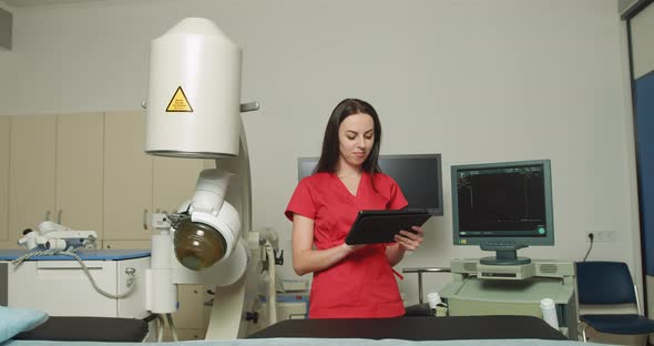 Close Up Portrait of Young Caucasian Woman Doctor in Red Uniform Holding Digital alt