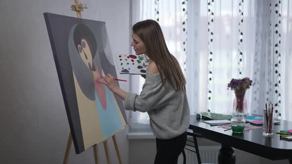 Side View Portrait of Absorbed Talented Woman Painting Abstract Modern Picture with Acrylic Paints alt