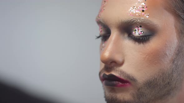 Applying Glitter on Face of Male Model alt