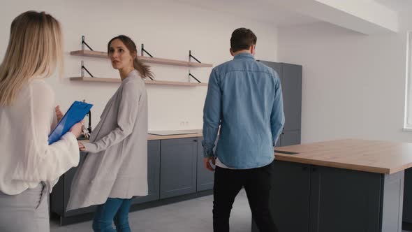 Real estate agent showing new house to young caucasian couple. Shot with RED helium camera in 8K alt