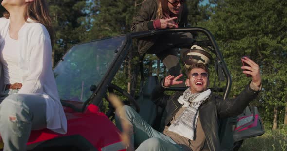 Group of Young Hipster Couple Enjoying Morning Sun on Off Road Car and Having Fun alt