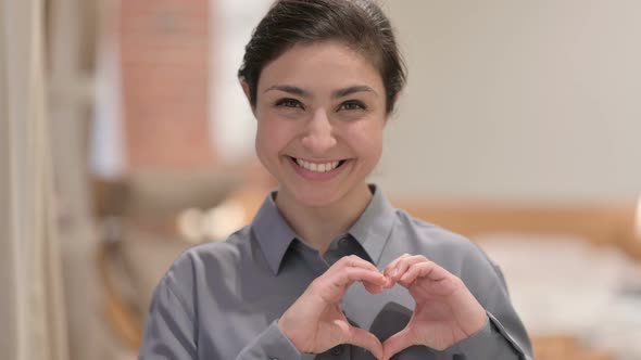Portrait of Young Indian Woman Making Heart Shape with Hands alt