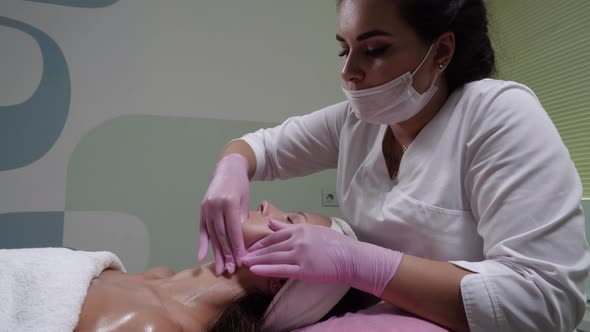 Cosmetologist Makes Buccal Facial Massage for an Attractive Woman.