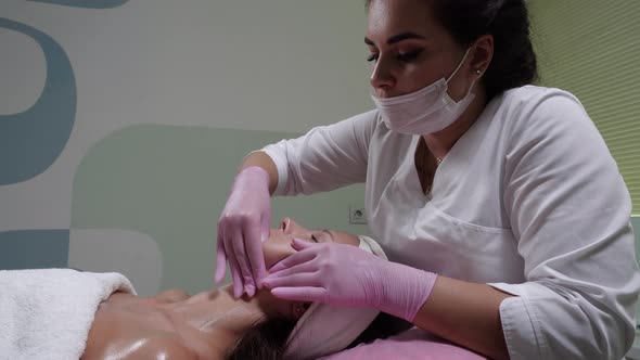 Cosmetologist Makes Buccal Facial Massage for an Attractive Woman. alt