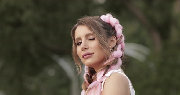 Beautiful Woman with Two Big Braids Looking at Camera