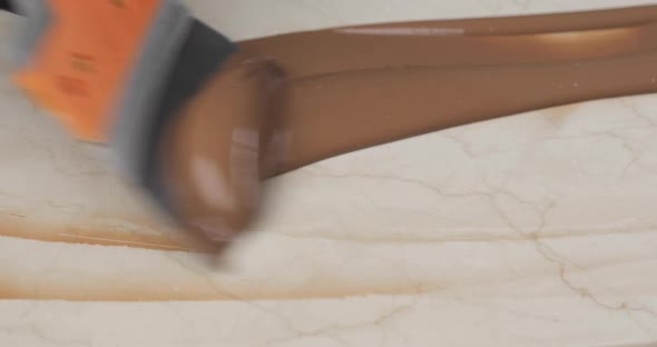 Melted Chocolate or Chocolate Cream is Spread Over the White Marble Surface with a Brush
