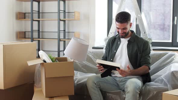 Happy Man Unpacking Boxes and Moving to New Home alt