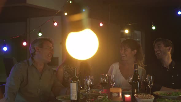 Friends laughing together at outdoor dinner party