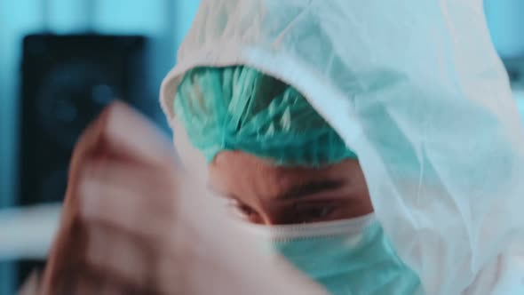 Portrait of Female Nurse Take Off Face Shield After Shift in Hospital Looking Up at Camera alt