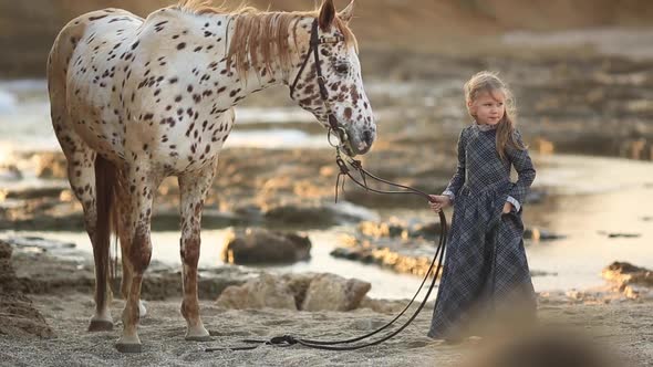 Little Girl in Dress Walking with a Horse