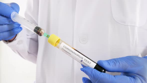 The syringe medical analyst analyzes blood from a Covid-19 positive test tube alt