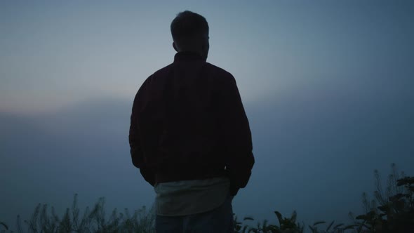 Relaxed Man Enjoying Sunrise in Field alt