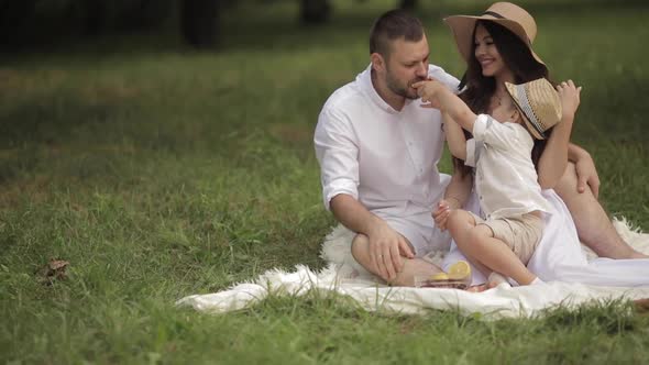 Family of Three Having a Picnic in the Glade