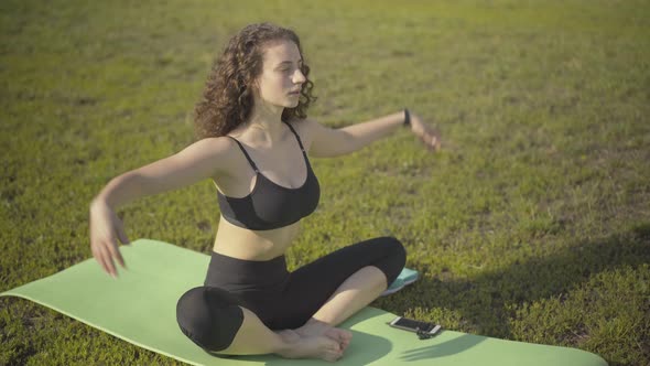 Relaxed Curly-haired Woman Putting Hands Together and Breathing Out. Portrait of Confident Caucasian alt