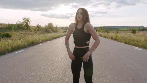 Pretty Sports Girl Doing Arms Warmingup on Road at Summer Nature in Morning alt