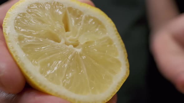 Professional chef squeezes lemon. Close up slow motion. alt