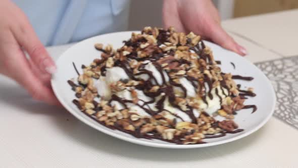 A Woman Demonstrates A Cake Made From Meringue, Cream And Chocolate. Close Up. alt