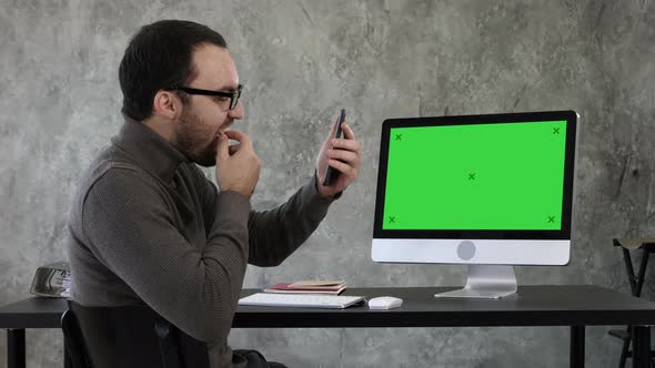Man Checking His Teeth in the Office Near Computer Screen alt