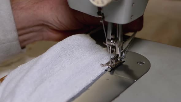 Tailor at Sewing Machine Sews a Homemade Medical Face Mask To Protect Covid-19 alt
