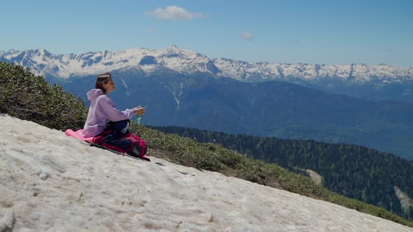 Girl Hiker Having a Rest After Climbing the Mountain alt