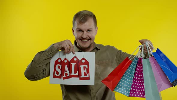 Happy Man Showing Sale Word Inscription, Smiling, Looking Satisfied with Low Prices, Slow Motion alt