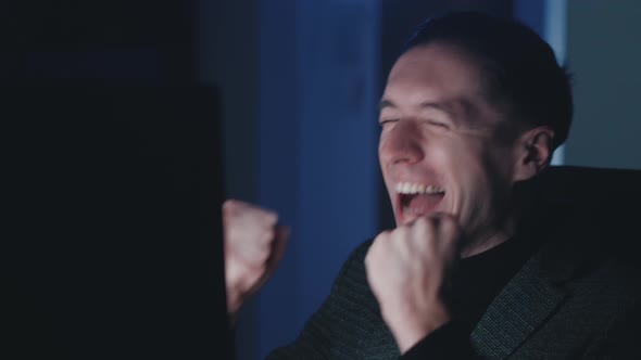 Excited Business Man Read Great News Using Computer Sitting Late at Office at Night alt