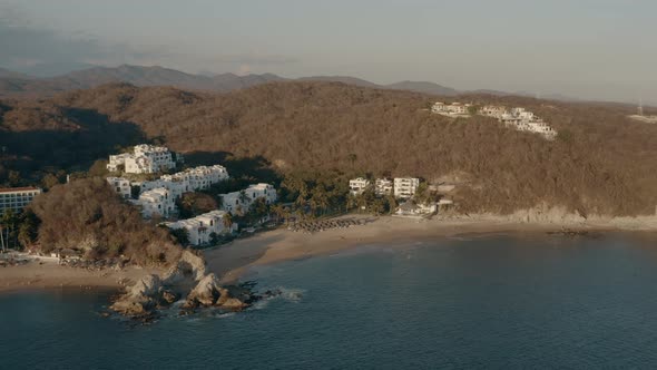 Winter sunset on pacific coastline. Hotels and villas near rocky beaches