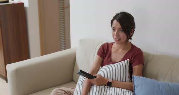 Woman watch on the tv at home alt