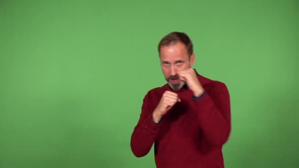 A Middleaged Handsome Caucasian Man Boxes the Camera  Green Screen Background