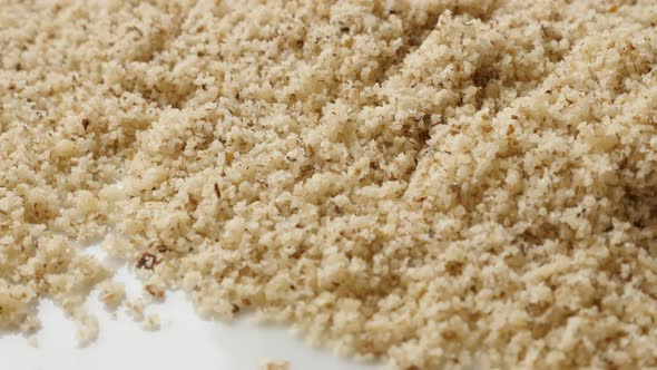 Grinded nuts food ingredient background  4K 2160p 30fps UltraHD tilting footage - Walnut seed choppe alt