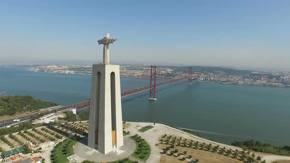 Aerial of Christ the King statue and 25th of April bridge