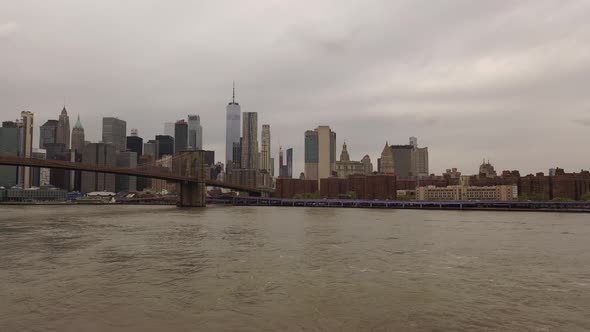 An aerial view over the East River on a cloudy day. The drone camera pan left on the north side of t alt