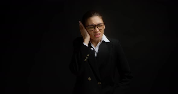 Business Woman in Glasses and Business Clothes Has a Sharp Pain in Her Ear alt