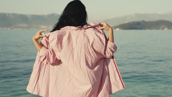 Slow Motion Video of a Girl Takes Off Her Shirt on the Beach and Goes Swimming alt