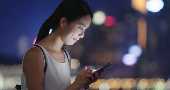 Woman use of mobile phone at night alt