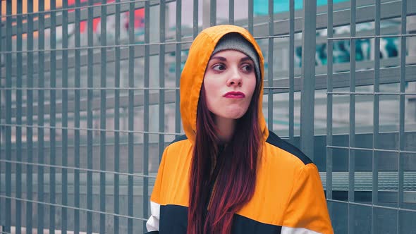 young hooded woman looks around  waiting for someone in a cold day alt